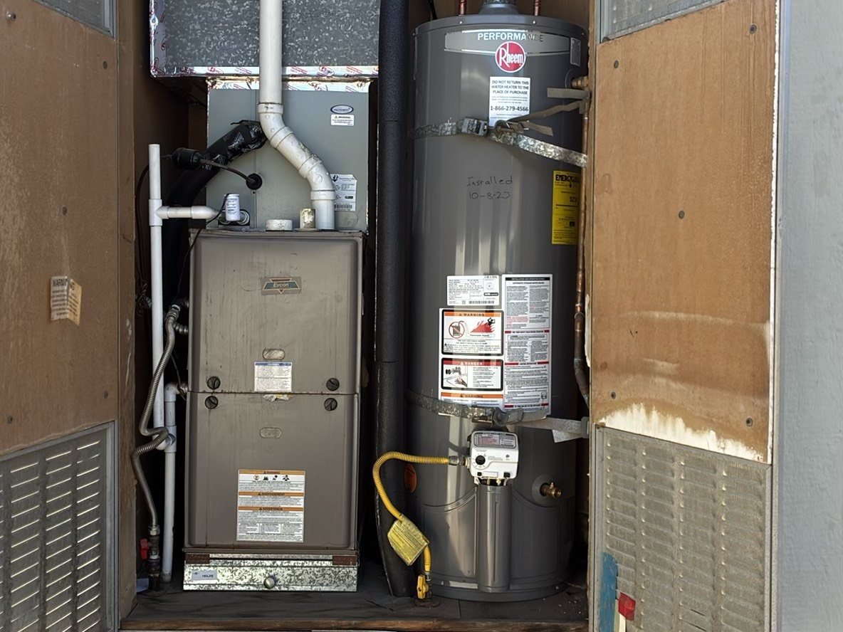 Gas furnace and water heater in a utility closet during a warranty inspection